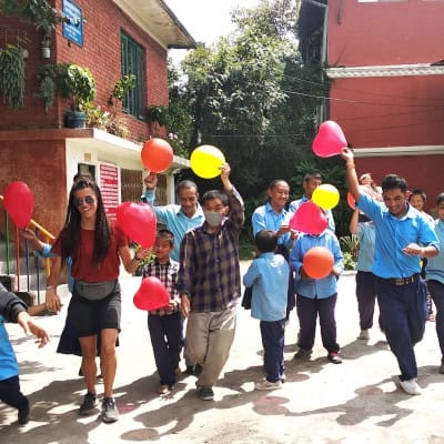 Freiwillige und Kinder feiern gemeinsam in einer Behindertenschule in Kathmandu – ein Moment voller Lebensfreude und Verbundenheit.