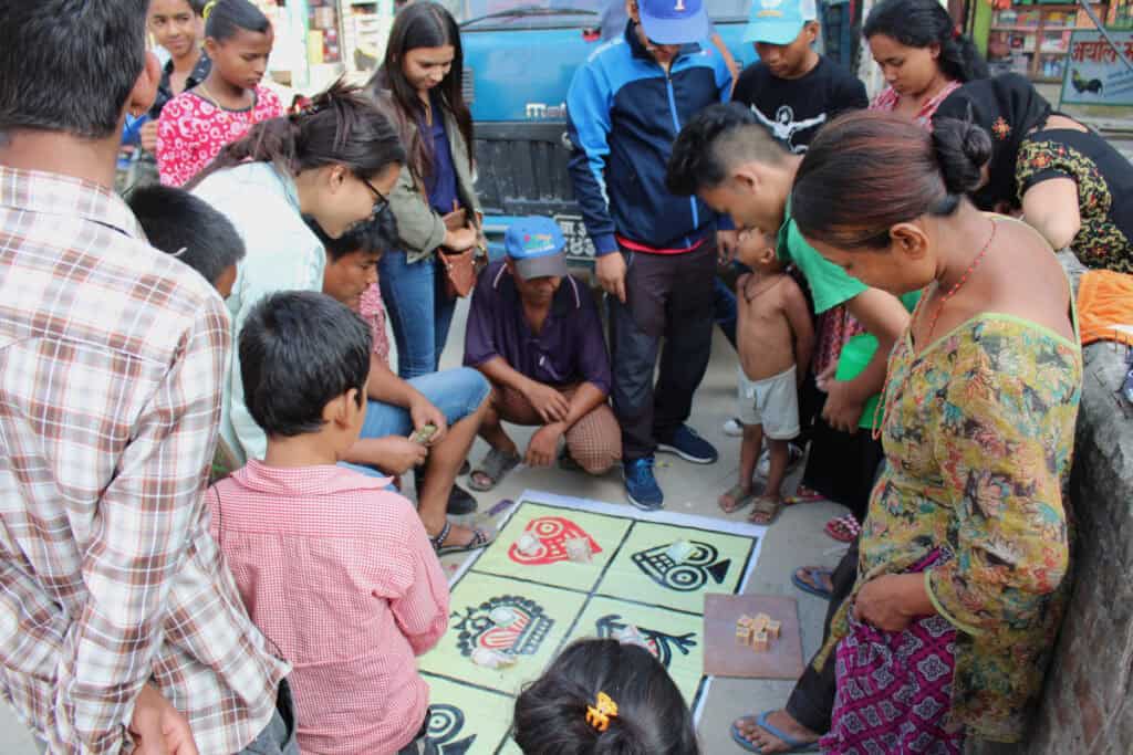 Menschen in Kathmandu versammeln sich auf der Straße zu einem Spiel während der Dashain- und Neujahrszeit – ein Symbol für Gemeinschaft, Freude und Zusammenhalt in Nepal.