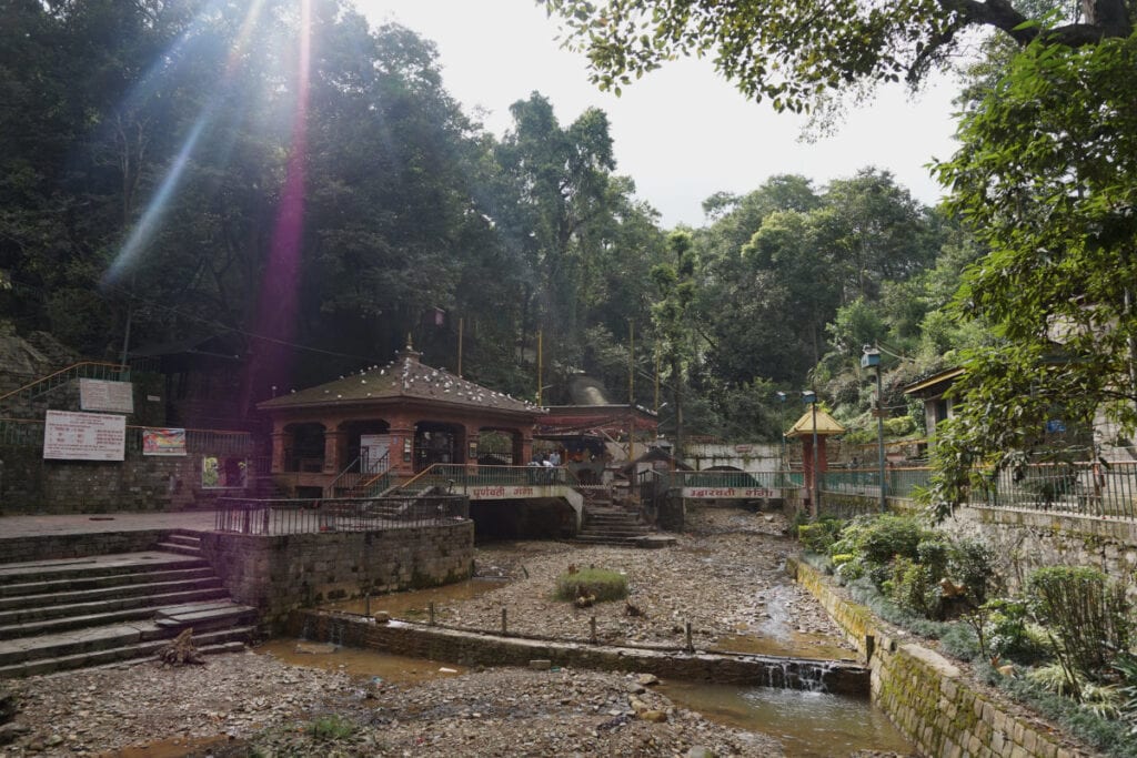 Sonnenstrahlen über einer alten Tempelanlage in Pharping, Nepal – ein stiller Ort, der die spirituelle Tiefe und den Ursprung nepalesischer Zeitvorstellungen widerspiegelt.