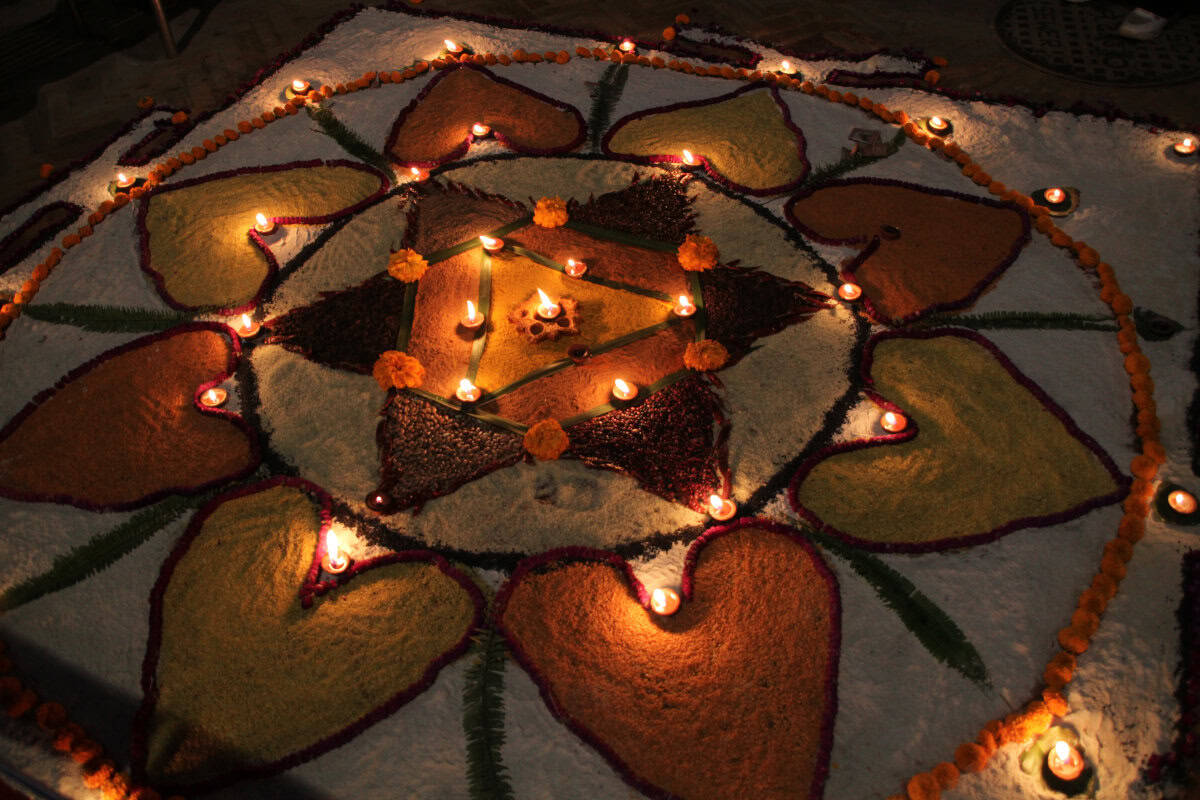 Mit buntem Pulver und kleinen Öllämpchen gestaltetes Mandala zum Tihar-Fest in Nepal