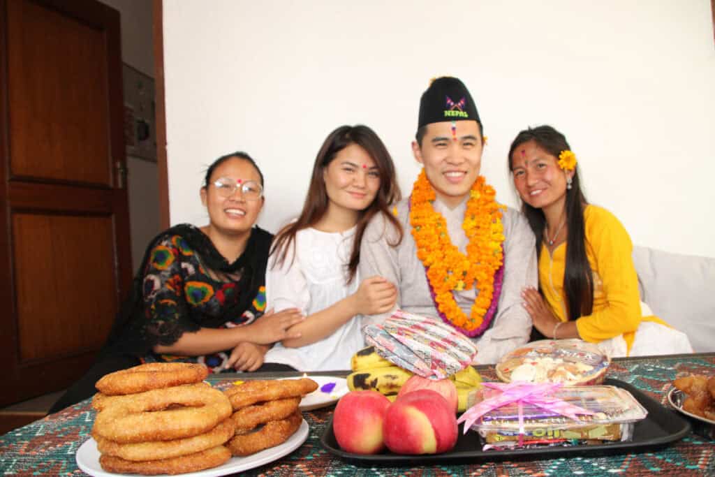 Khai mit drei nepalesischen Schwestern während des Tihar-Festes 2019 in Kathmandu – gemeinsam beim Brüder-Segen mit traditionellen Speisen, Blumenketten und festlicher Stimmung