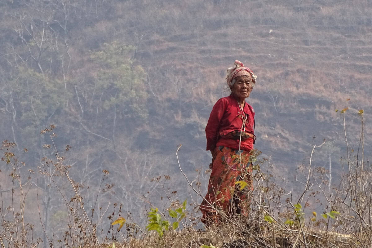 Ältere Frau in traditioneller Kleidung auf einem Hügel in Dhankuta – Symbol für die kulturelle und sprachliche Vielfalt Nepals