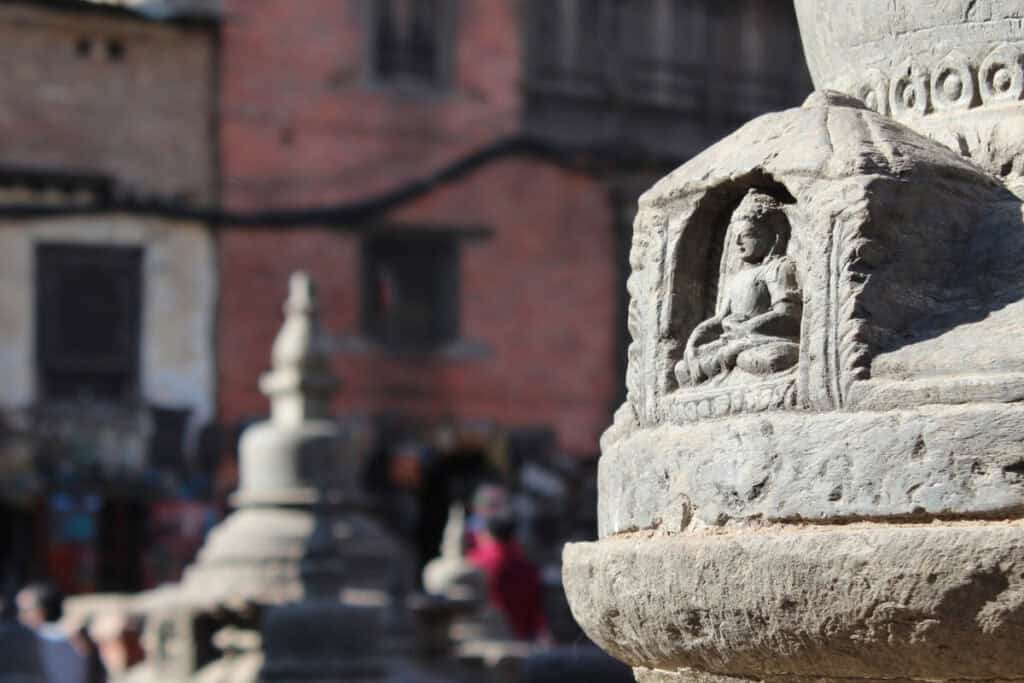 Buddha-Steinrelief in einem alltäglichen Umfeld in Kathmandu – Beispiel für die selbstverständliche Präsenz buddhistischer Motive im religiösen Alltag Nepals.