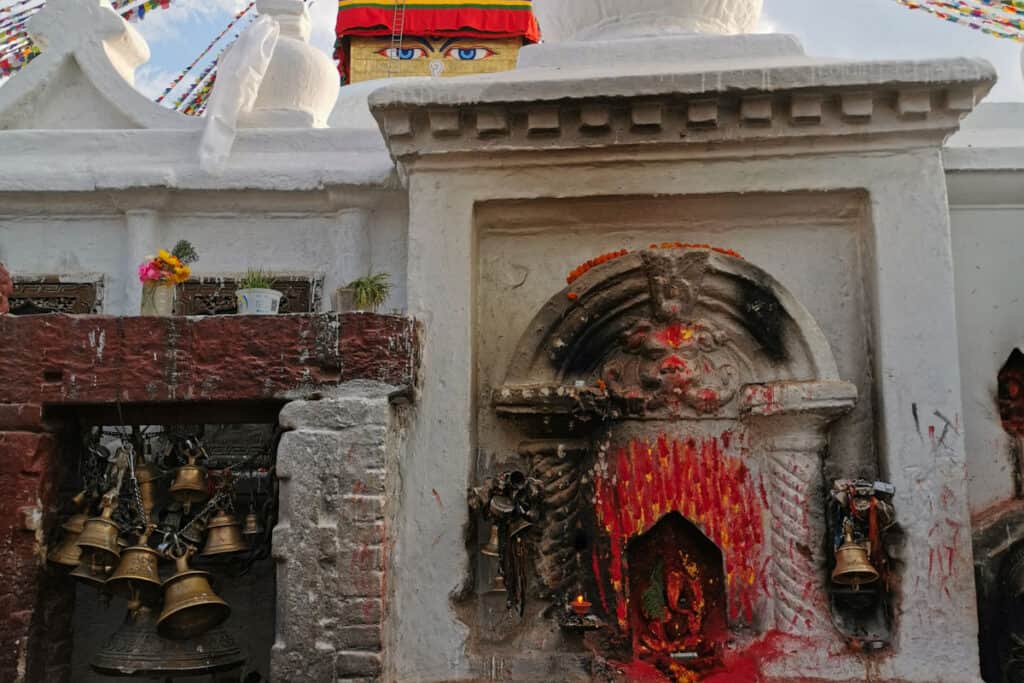 Hinduistischer Ganesha-Schrein vor der buddhistischen Boudha-Stupa in Kathmandu – ein Beispiel für das enge Zusammenspiel von Hinduismus und Buddhismus.