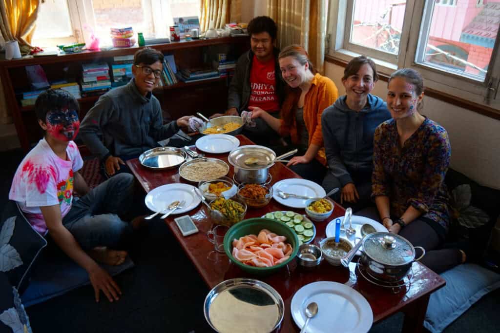 Gemeinsames Leben im Homestay – Alltag und Feste teilen Gemeinsames Essen und Holi-Feier in einem nepalesischen Homestay mit lokalen Gastgebern und Gästen