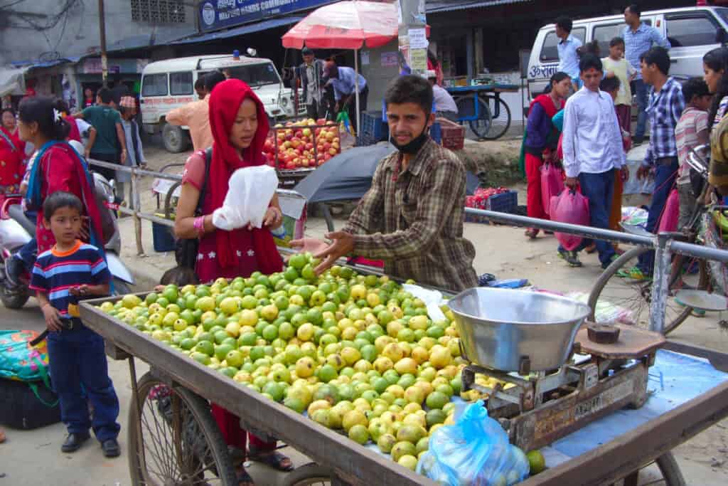 Straßenverkauf in Nepal: Eine Familie verkauft Obst im öffentlichen Raum – informelle Arbeit als wichtiger Bestandteil des urbanen Alltags.