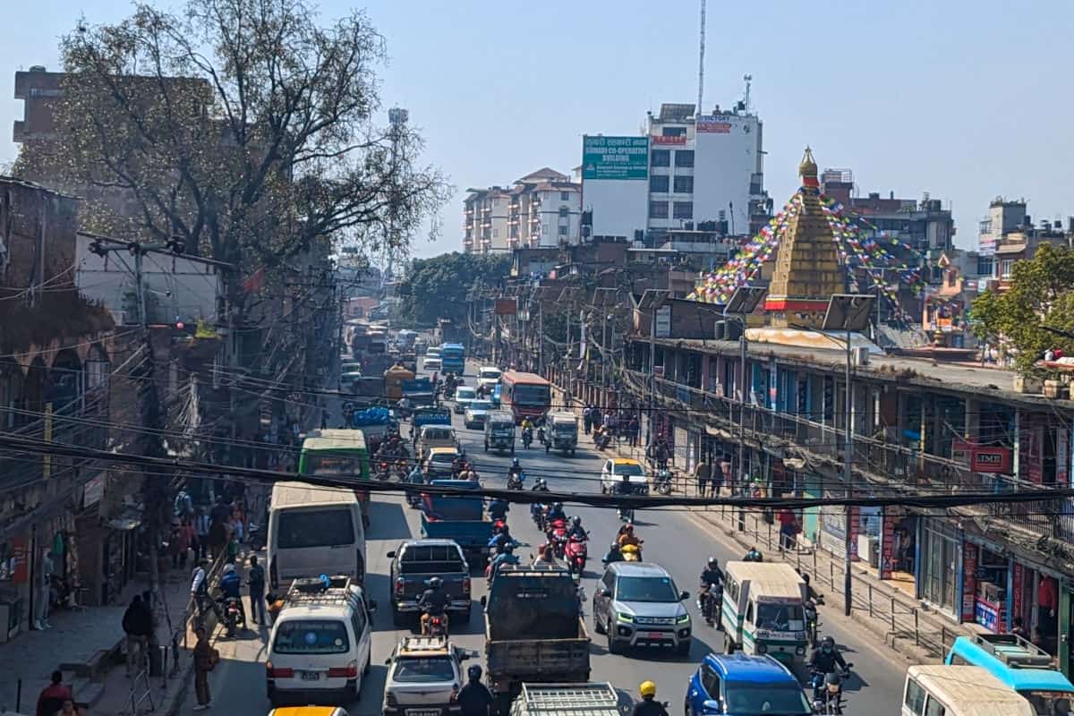 Verkehr und Alltag in Kathmandu mit Motorrädern, Autos, Tempel und Häusern