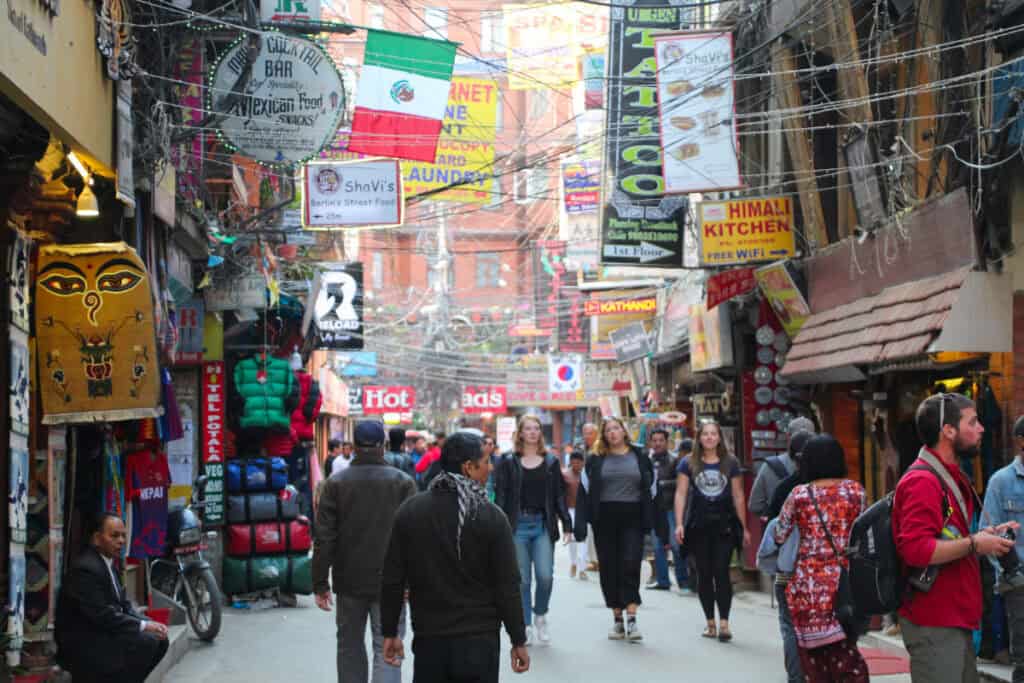 Thamel – Alltag im Touristenviertel Belebte Straße im Viertel Thamel in Kathmandu mit Shops, Reisenden und dichtem Kabelgewirr