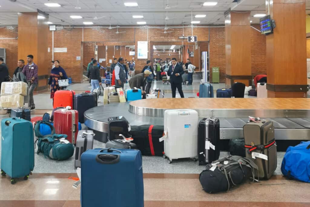 Gepäckausgabe am Tribhuvan International Airport in Kathmandu mit Koffern neben dem Förderband