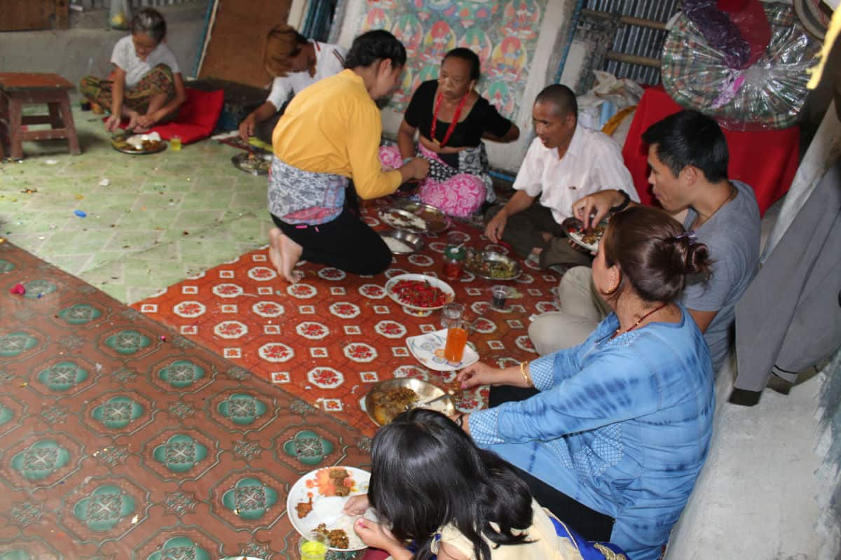 Gemeinsames Essen im nepalesischen Alltag: Familie sitzt auf dem Boden und teilt eine Mahlzeit.