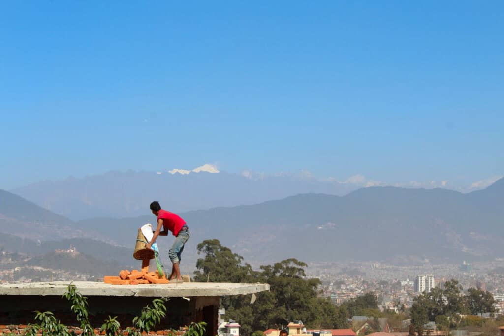 Arbeiten auf einem Dach bei klarer Sicht während der Trockenzeit in Kathmandu
