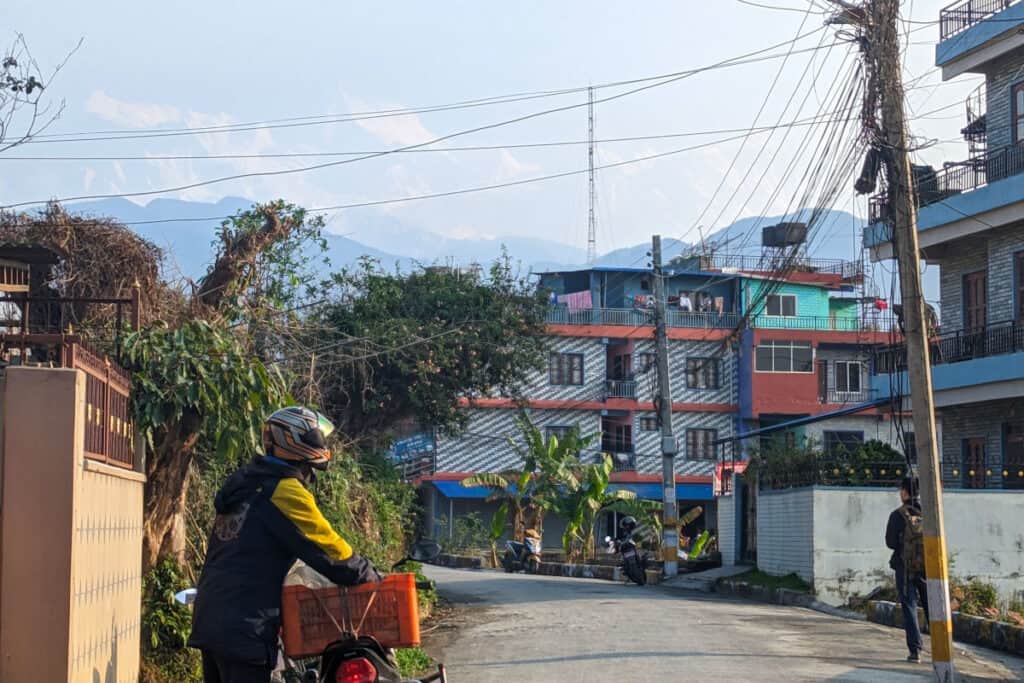 Ruhigere Wohnlage außerhalb von Lakeside Ruhige Straße in Pokhara außerhalb von Lakeside mit Wohnhäusern, Kabeln und Motorradfahrer