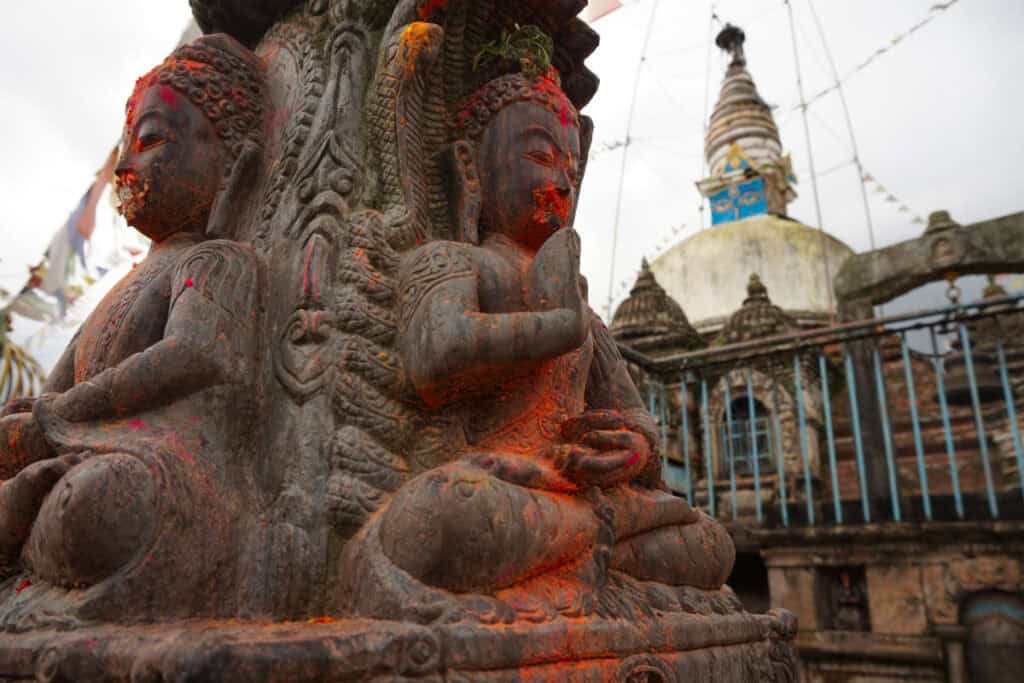 Mit rotem Pulver markierte Steinfigur an einem Straßenschrein in Kirtipur – Beispiel für gelebte Alltagsreligion in Nepal.