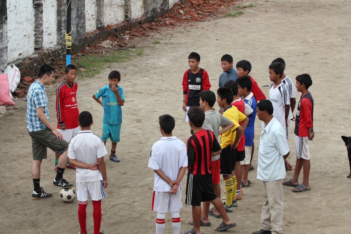 Volunteer leitet ein Fußballtraining mit Jugendlichen in Nepal