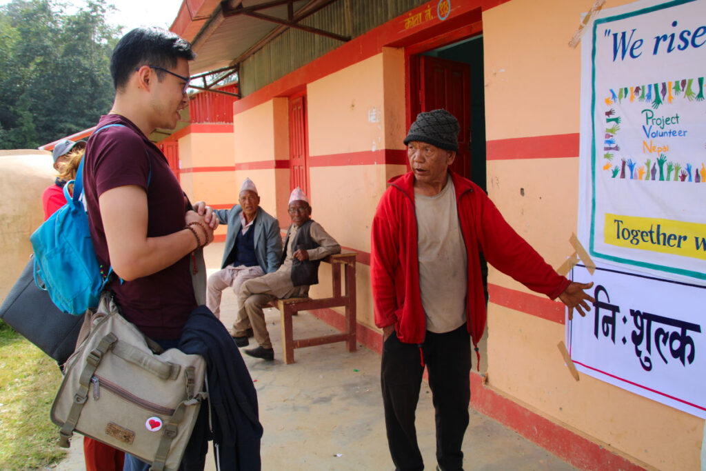 Gespräch auf Augenhöhe in Nepal Khai-Thai im Gespräch mit einem älteren Mann vor einem Gebäude in Nepal