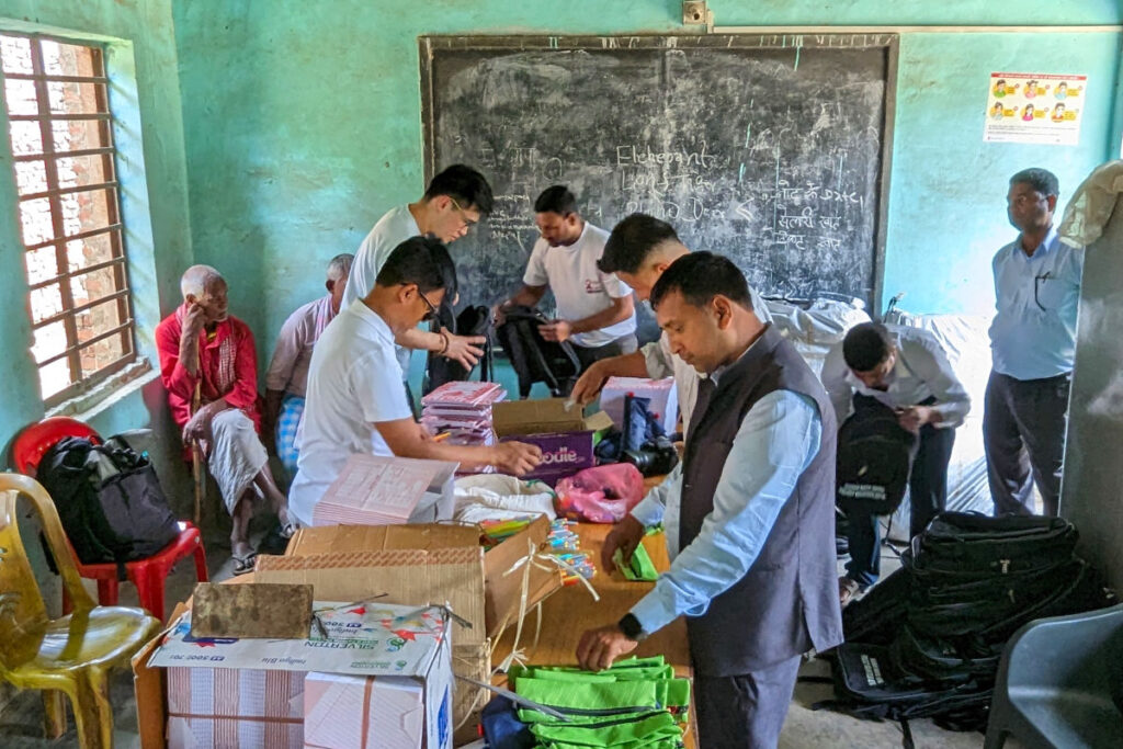 Lokale Partner organisieren Schulmaterialien in einem Klassenzimmer in Nepal