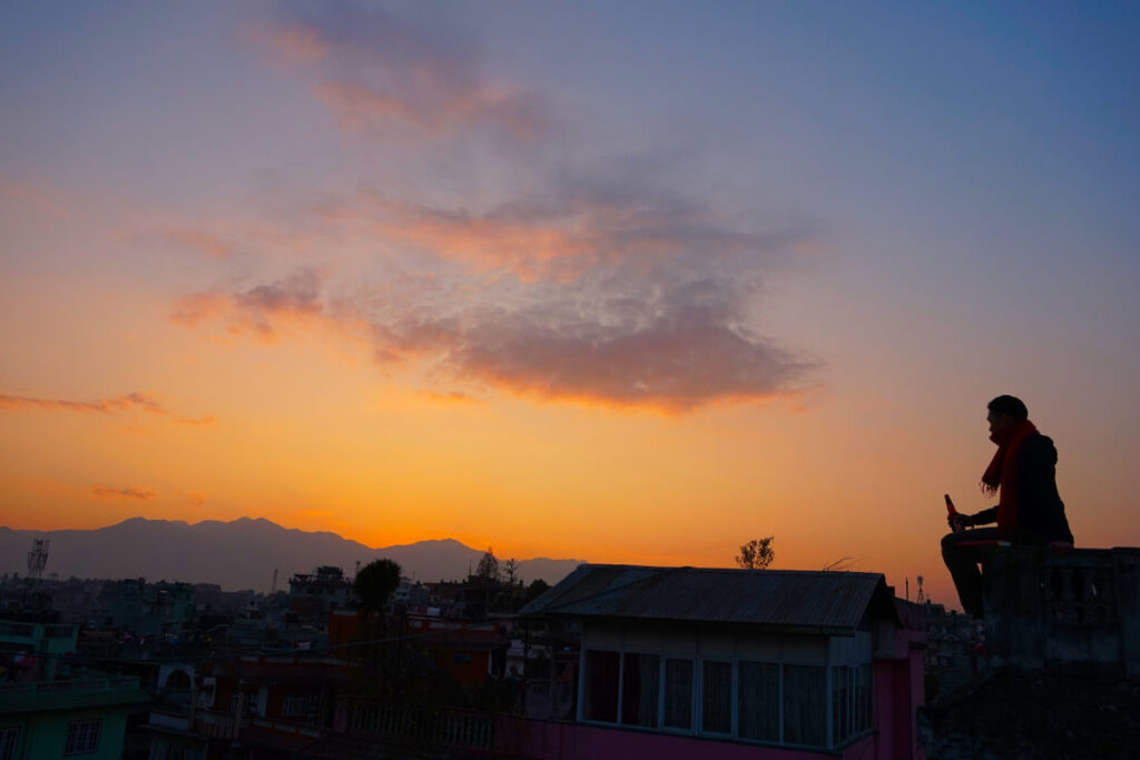 Reflexion über den Dächern Nepals Silhouette von Khai-Thai auf einer Dachterrasse in Nepal bei Sonnenuntergang