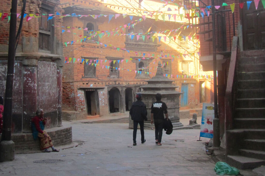 Ruhige Gasse in Nepal mit zwei Personen unter bunten Fahnen