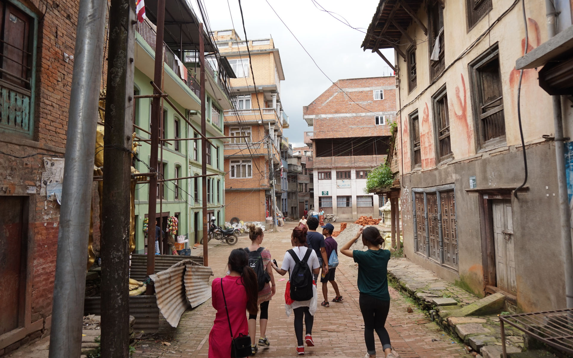 Reisende unterwegs durch ein nepalesisches Stadtviertel abseits touristischer Routen
