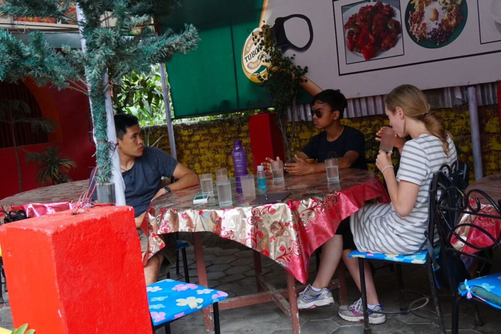 Reisende im Gespräch mit Locals in einem Café in Nepal
