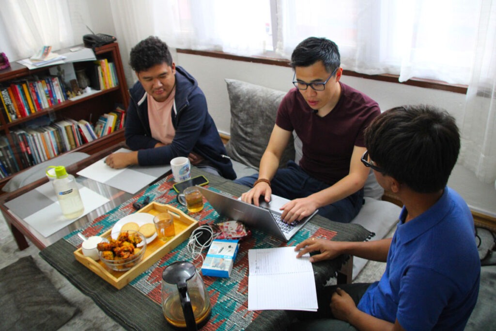 Rajeev, Vishal und Partner besprechen Projektinhalte gemeinsam am Tisch