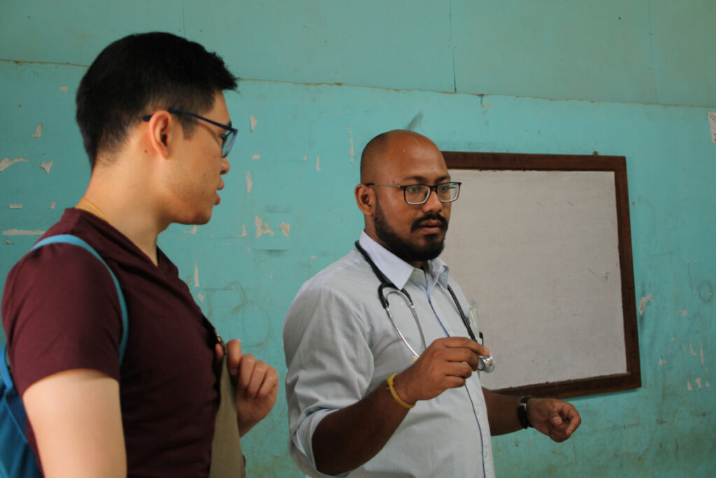 Project Volunteer Nepal – Zusammenarbeit mit lokalen Ärzten Volunteer im Gespräch mit einem nepalesischen Arzt während eines Medical Camps