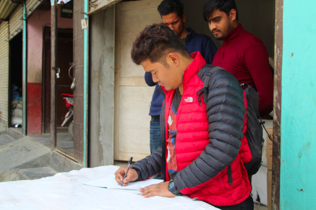 Vishal unterzeichnet Dokumente im Rahmen eines Projektbesuchs in Nepal