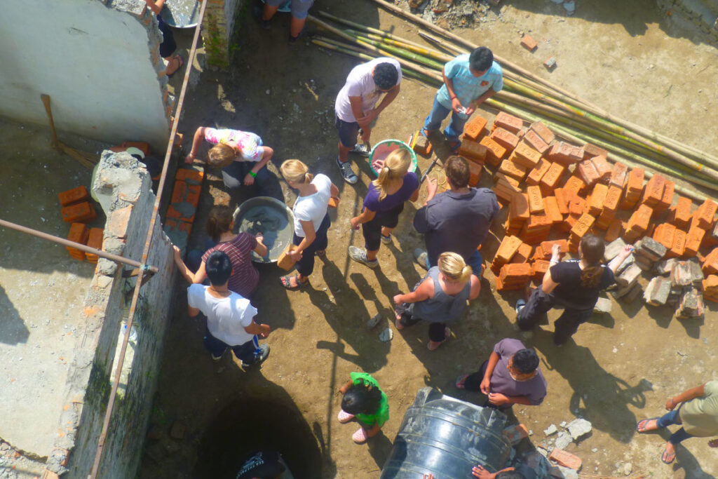 Bauprojekt mit internationalen Volunteers in Nepal Internationale Volunteers arbeiten gemeinsam an einem Bauprojekt in Nepal, aufgenommen aus der Vogelperspektive