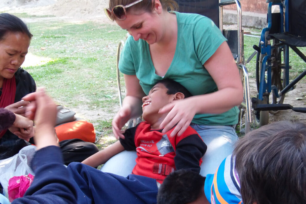 Freiwilligenarbeit in einer nepalesischen Behindertenschule Volunteer unterstützt ein Kind in einer Behindertenschule in Nepal