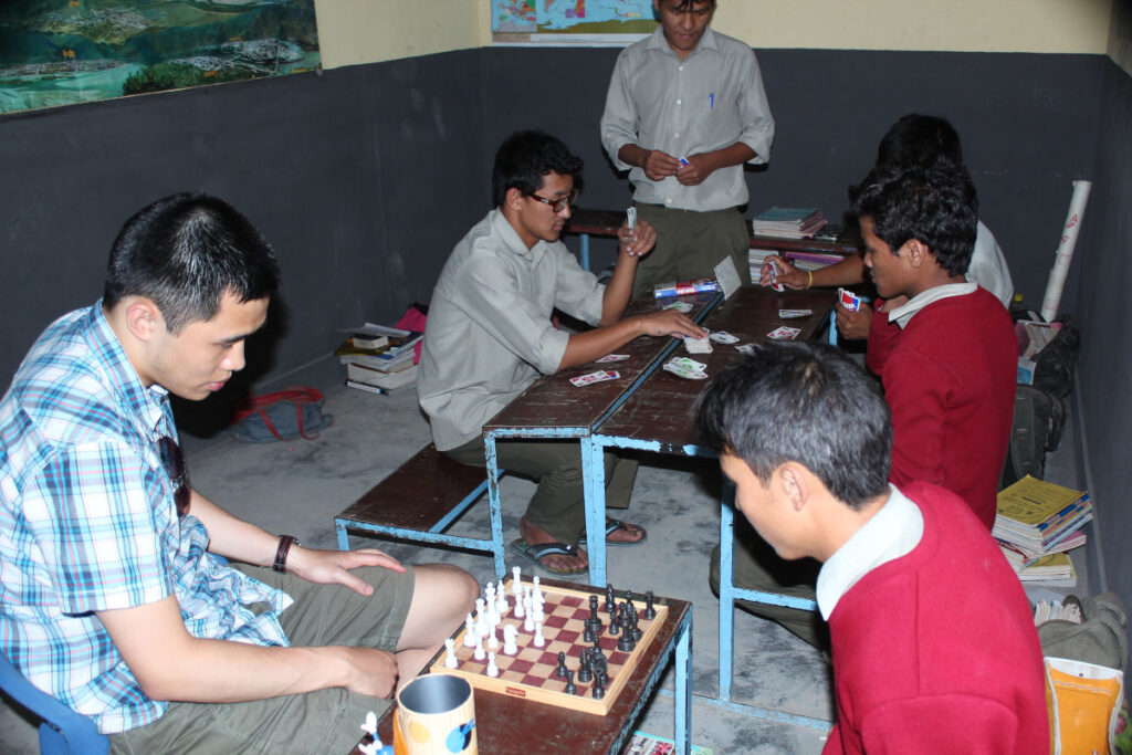 Volunteering in Nepal – Unterricht ohne klare Aufgabe Volunteer sitzt mit Schülern in einem Klassenraum ohne klar definierte Unterrichtsrolle