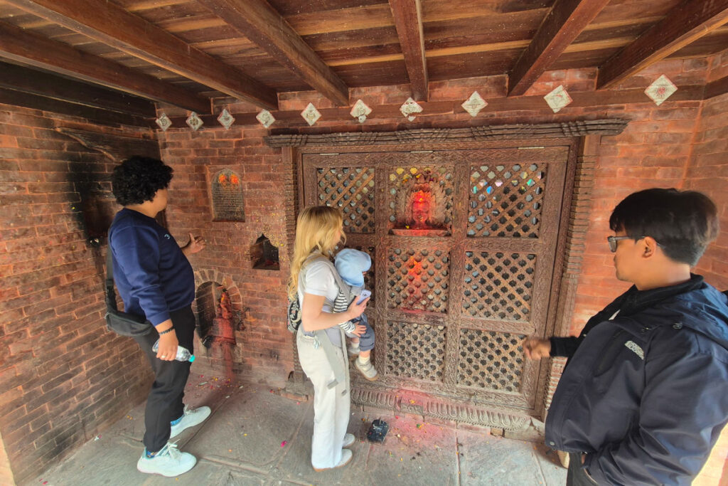 Lokaler Guide erklärt Reisenden einen Schrein in Kirtipur, Nepal