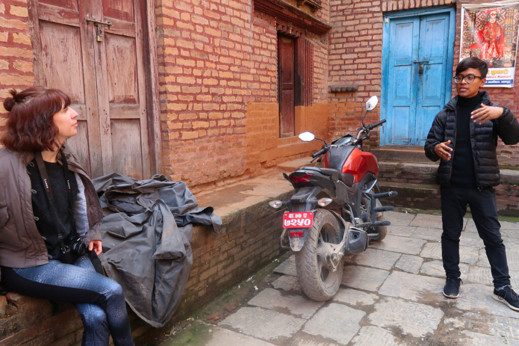 Rajeev erklärt Reisenden eine Szene in einer Gasse in Kathmandu, Nepal