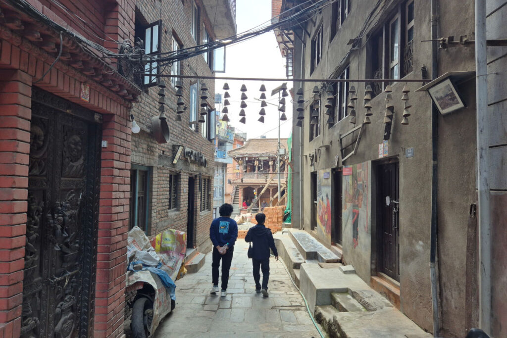 Rajeev und Vishal gehen durch eine Gasse in Kirtipur, Nepal