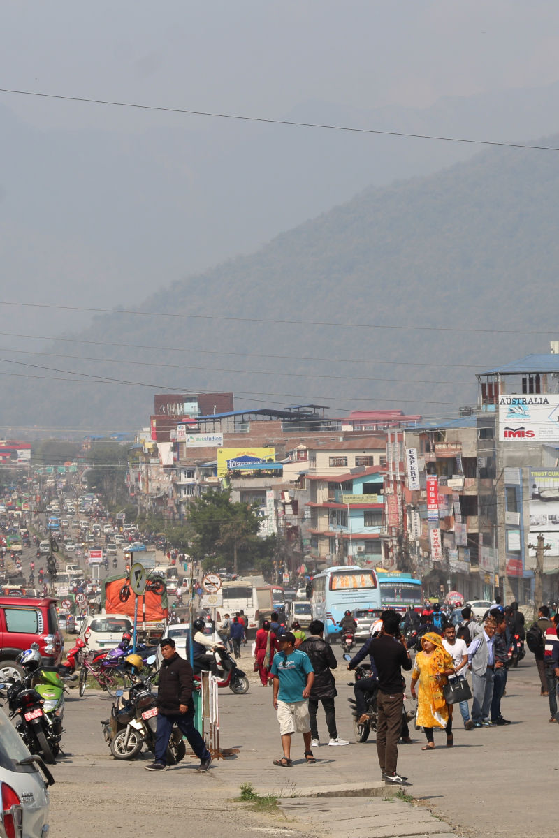 
Belebte Straße in Bharatpur mit Verkehr, Motorrädern und Menschen im Alltag