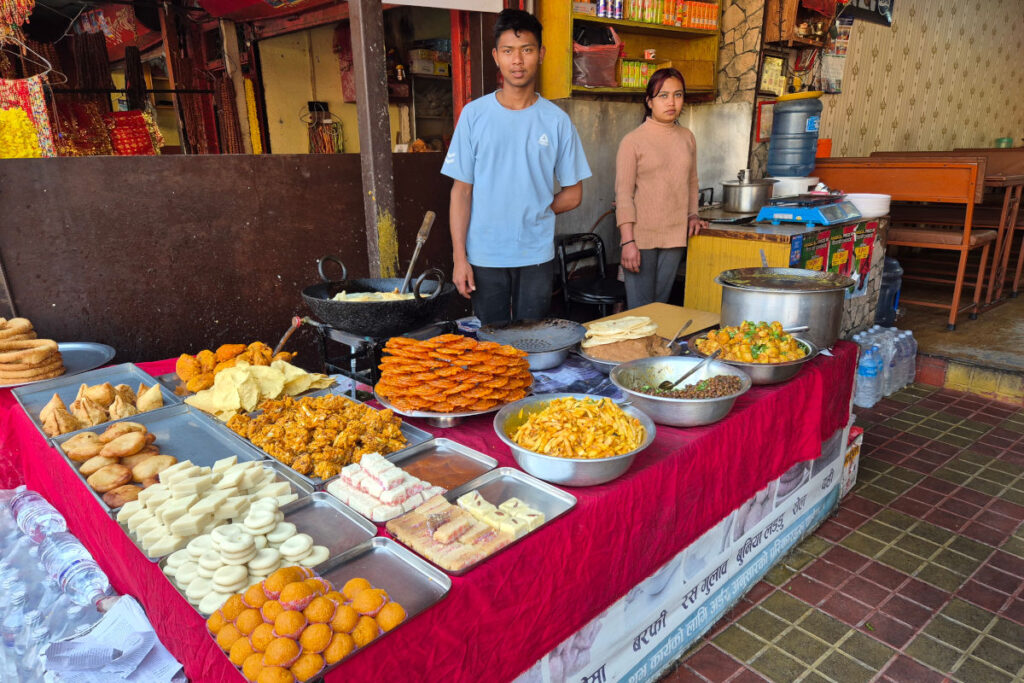 Garküche in Nepal – Bezahlen im Alltag Straßenstand mit nepalesischem Essen und Verkäufern