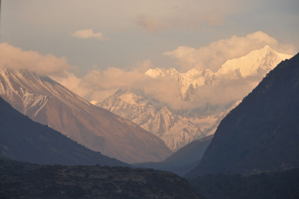Bergtal mit Blick auf Himalaya-Gipfel Bergtal in Nepal mit schneebedeckten Himalaya-Gipfeln im Hintergrund