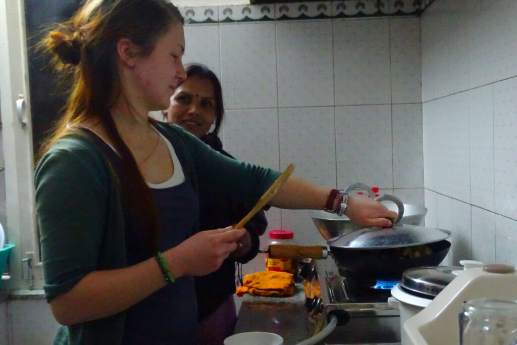 Gast lernt in einer Küche in Kathmandu, wie traditionelle nepalesische Gerichte zubereitet werden