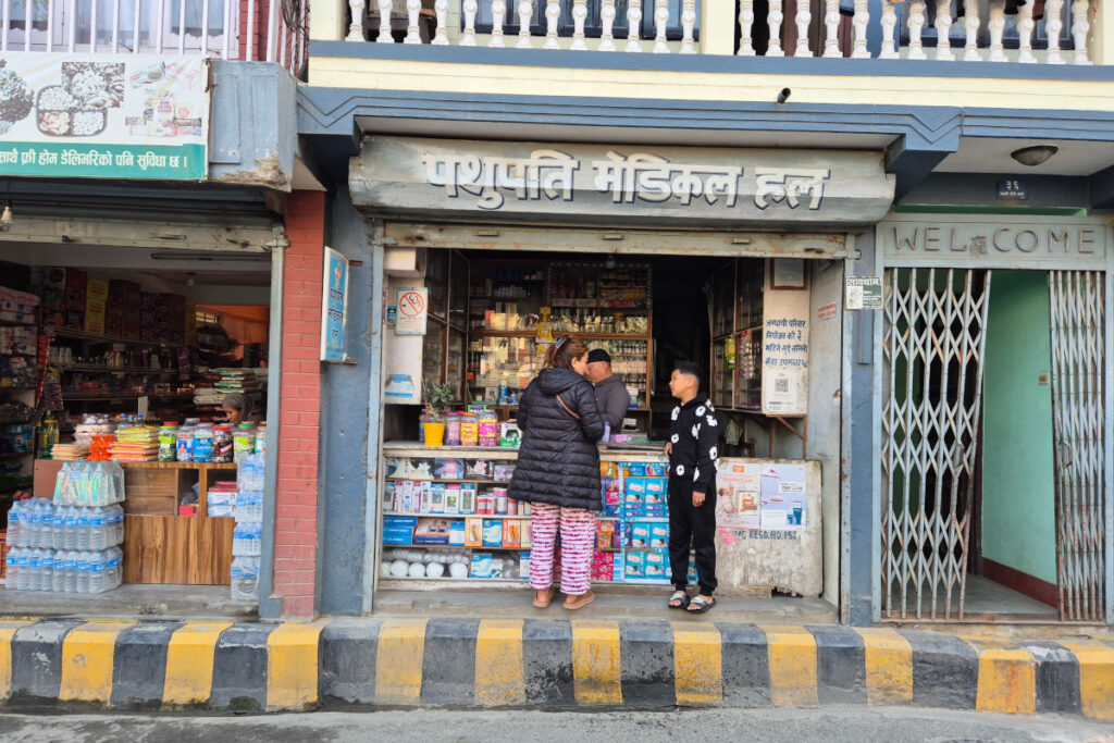 Straßenszene in Kathmandu mit kleinem Laden und Apotheke im lokalen Alltag
