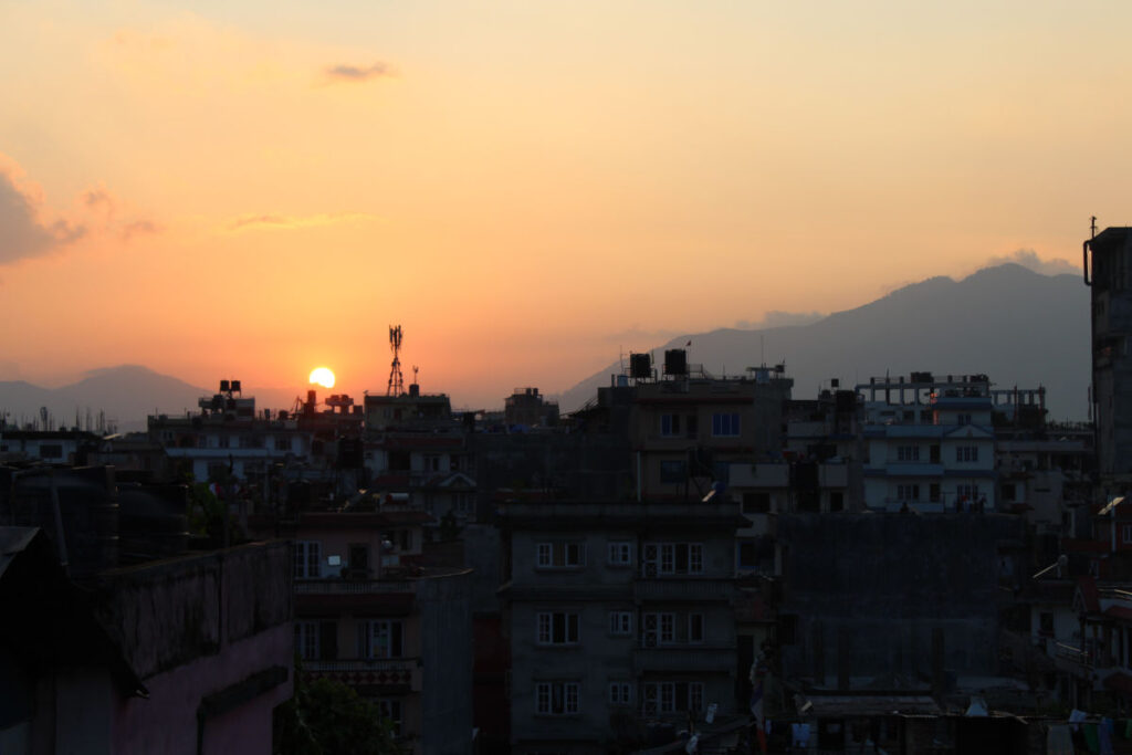 Sonnenuntergang über Kathmandu mit Blick auf Dächer und Berge