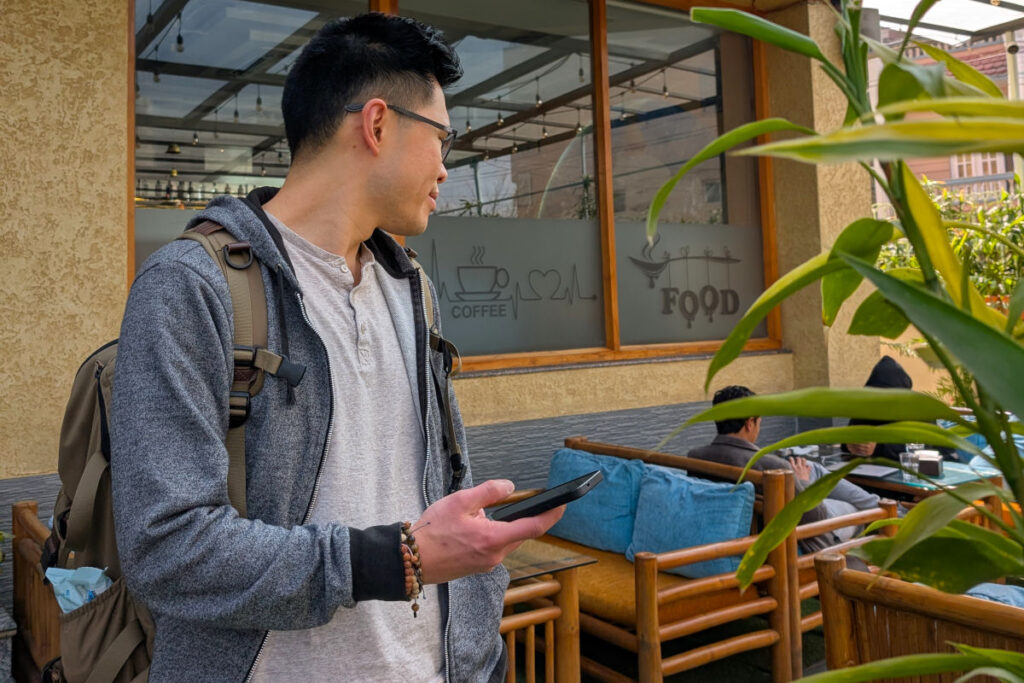 Mobiles Internet im Alltag in Nepal Reisender nutzt Smartphone in einem Café in Nepal