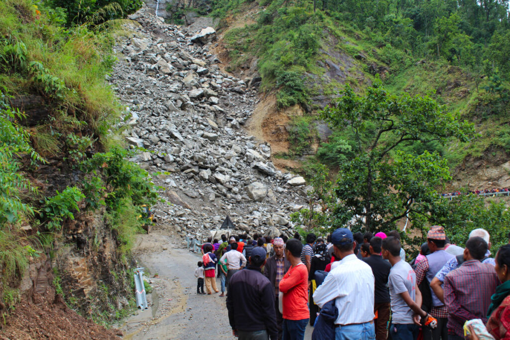 Straße in Nepal durch Erdrutsch blockiert mit wartenden Menschen
