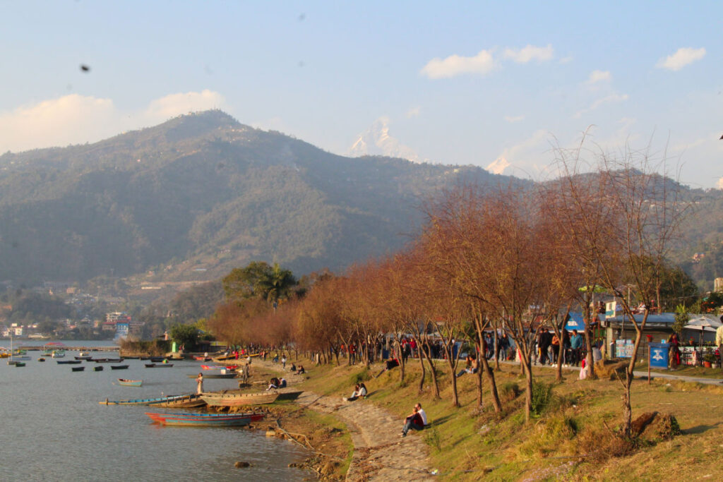 Menschen spazieren entlang der Uferpromenade am Phewa-See in Pokhara