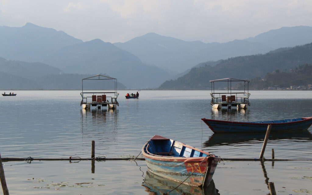Phewa-See in Pokhara mit Booten und Bergkulisse Boote auf dem Phewa-See in Pokhara mit Blick auf die umliegenden Berge