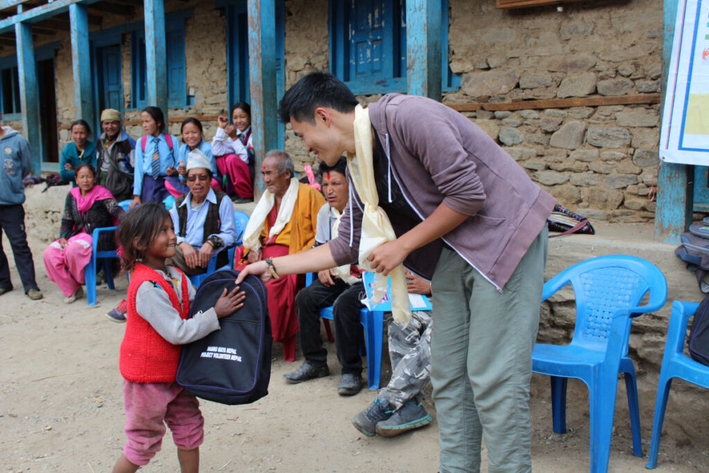 Schultaschen-Projekt in Dolpo | meinNepal & hamromaya Nepal e.V. Kind erhält Schulrucksack beim Schultaschen-Projekt im Dorf Hurikot in Dolpo, Nepal