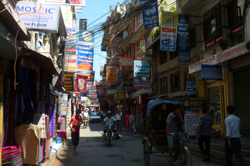 Straße in Thamel mit vielen Schildern für Hotels, Restaurants und Trekking-Agenturen