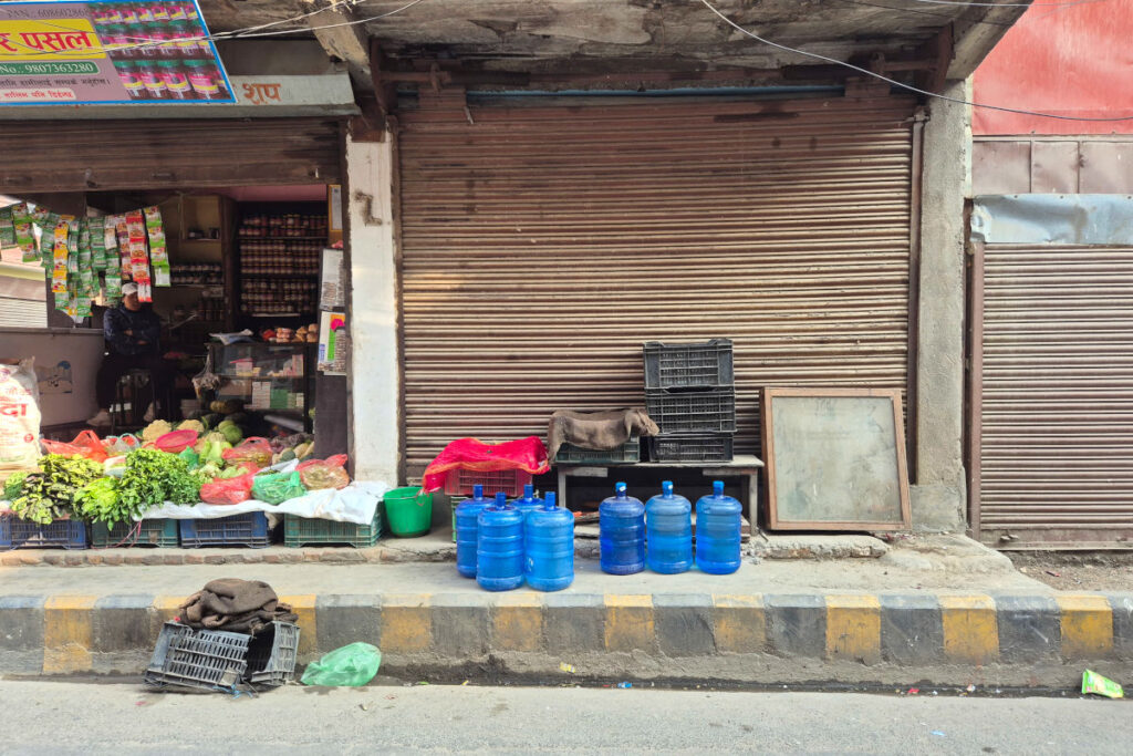 Wasserkanister vor einem kleinen Straßenladen in Nepal