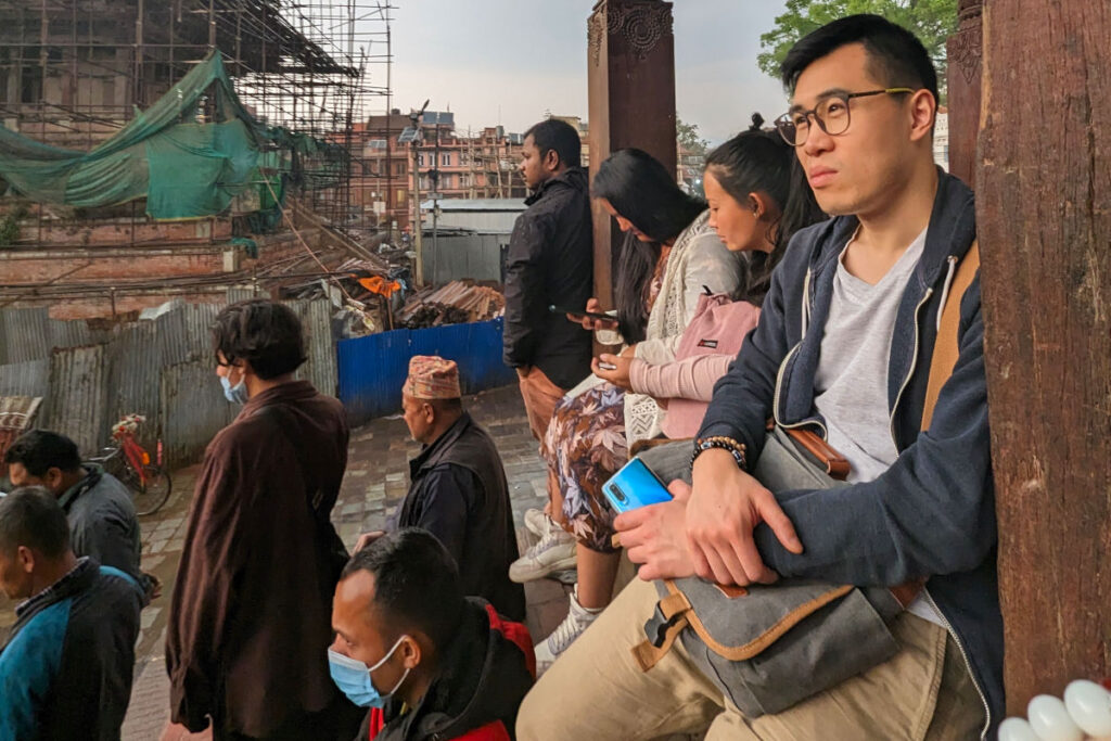 Ankommen im Alltag von Kathmandu Reisender sitzt und beobachtet das Alltagsleben in Kathmandu