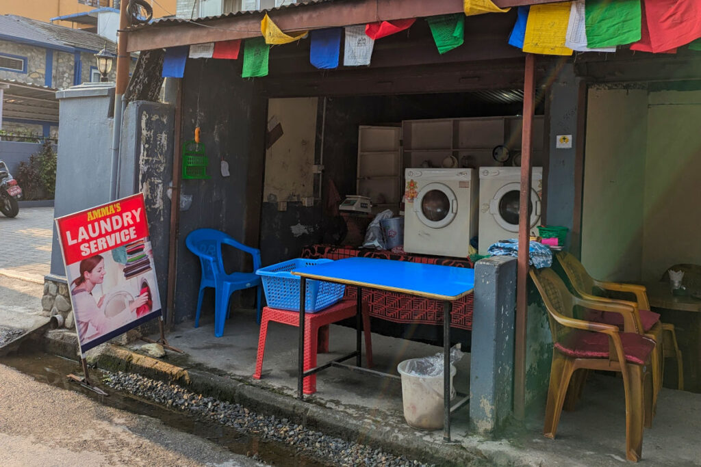 Kleine Wäscherei in Nepal mit Waschmaschinen und Sitzgelegenheiten am Straßenrand