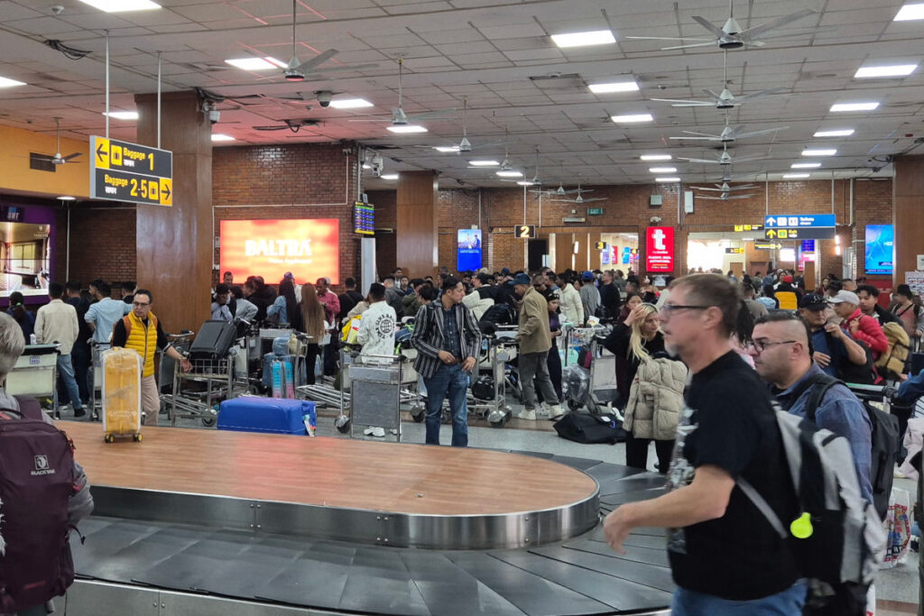 Gepäckausgabe am Tribhuvan Airport in Kathmandu Reisende stehen dicht gedrängt an der Gepäckausgabe am Tribhuvan Airport in Kathmandu mit vielen Trolleys und Koffern