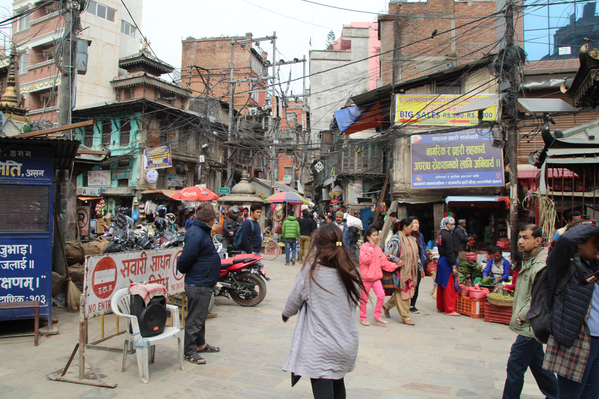 Belebte Straße mit Marktständen und Geschäften in der Altstadt von Kathmandu